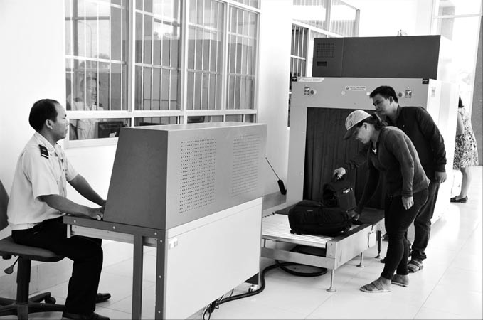 Hành khách cho hành lý đi qua máy soi chiếu của hải quan để kiểm tra​. Ảnh: Tuấn Nguyễn.