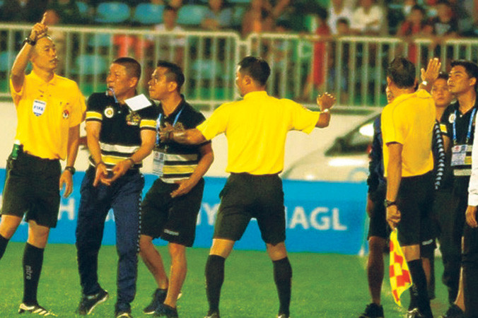 HLV Chu Đình Nghiêm của CLB Hà Nội lao vào sân phản đối quyết định của trọng tài Ngô Duy Lân.