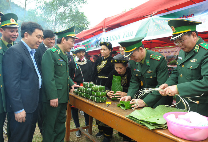 Bộ đội Biên phòng cùng đồng bào gói bánh chưng vui ngày hội “Xuân Biên phòng ấm lòng dân bản”. Ảnh: Xuân Tùng.