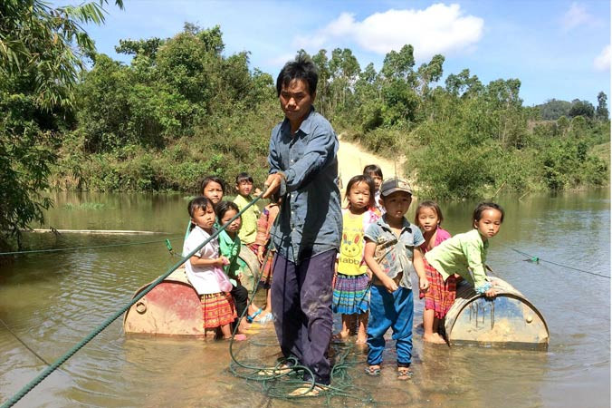 Người dân, trẻ nhỏ Ea Rớt trên chiếc bè tạm.