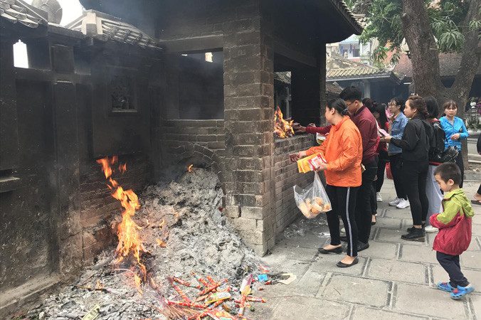 Bên cạnh sự chuyển biến tích cực, nhiều người dân vẫn đốt vàng mã tại chùa. Ảnh: Nguyên Khánh.