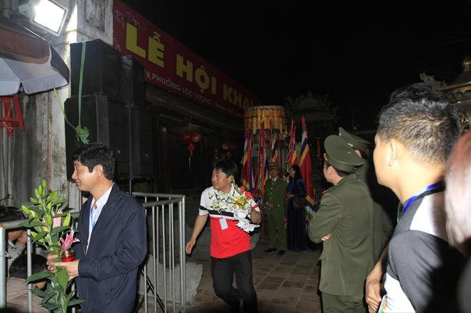 Đại biểu đeo thẻ mang theo lộc từ đền Thiên Trường ra về trước ánh mắt của hàng nghìn du khách. Ảnh: Trường Phong.