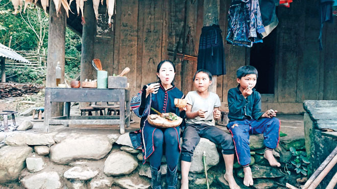 Vương Anh cùng em nhỏ người bản địa thưởng thức món ăn vừa làm xong.