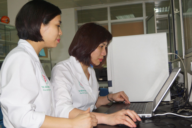 Trung úy Đào Thanh Quyên (bên trái) và thượng úy Trần Thị Thanh Huyền, khoa Sinh học phân tử, Bệnh viện T.Ư Quân đội 108 đang phân tích và thảo luận kết quả xét nghiệm chẩn đoán vi khuẩn gây nhiễm khuẩn huyết. Ảnh: Nguyễn Minh.