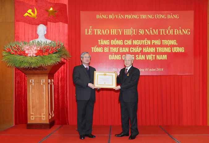 Ông Trần Quốc Vượng, Ủy viên Bộ Chính trị, thành viên Thường trực Ban Bí thư, Chủ nhiệm Ủy ban Kiểm tra T.Ư trao Huy hiệu 50 năm tuổi Đảng tặng Tổng Bí thư Nguyễn Phú Trọng. Ảnh: TTXVN.