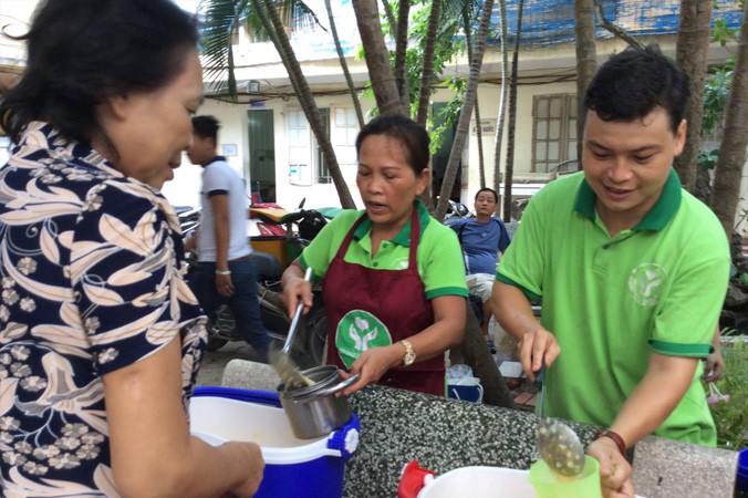Lê Huy (ngoài cùng bên phải) đang phát cháo cho bệnh nhân ở Bệnh viện K (Quán Sứ, Hà Nội). Ảnh: Bình Minh.
