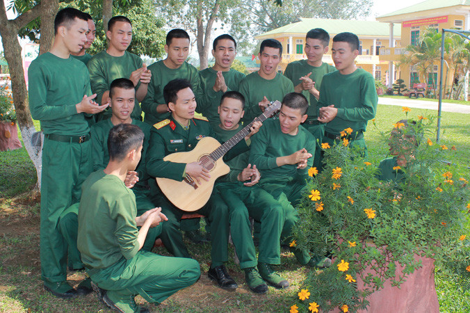 Giờ giải lao của cán bộ, chiến sĩ Tiểu đoàn 18 thuộc Sư đoàn 324 trên bãi tập đang cùng nhau đọc báo, ca hát tạo không khí vui tươi, thoải mái. Ảnh: Lê Tường Hiếu.