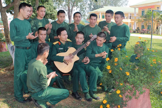 Giờ giải lao của cán bộ, chiến sĩ Tiểu đoàn 18 thuộc Sư đoàn 324 trên bãi tập đang cùng nhau đọc báo, ca hát tạo không khí vui tươi, thoải mái. Ảnh: Lê Tường Hiếu.