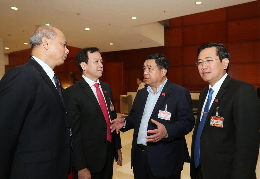 Các đại biểu trao đổi bên hành lang Đại hội XIII của Đảng. Ảnh: Như Ý 