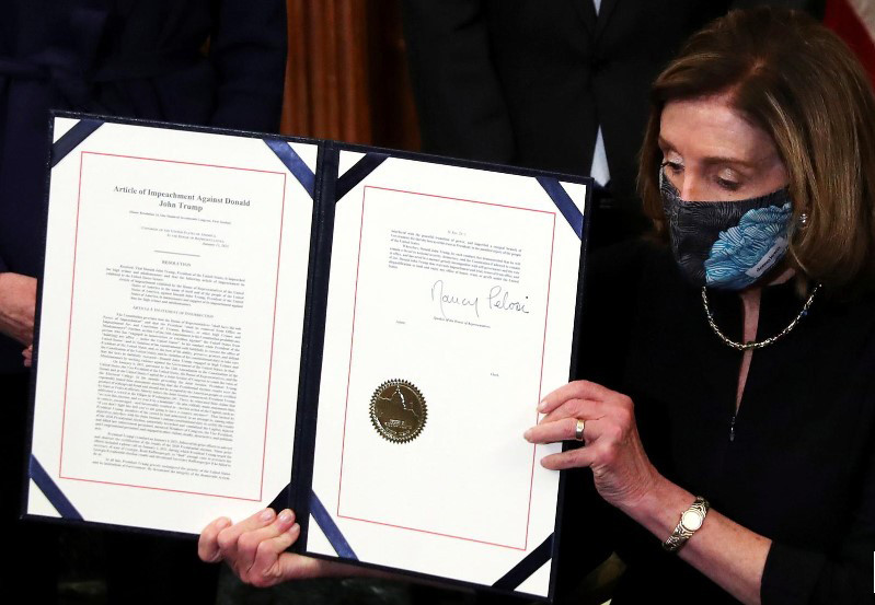 Chủ tịch Hạ viện Nancy Pelosi trưng ra văn bản thông qua việc luận tội tổng thống Trump sau khi ký phê chuẩn ảnh: Reuters 