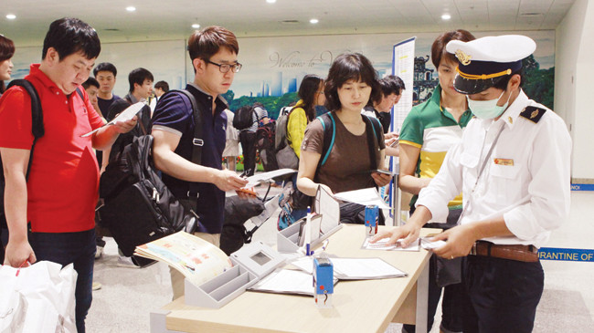 Hành khách Hàn Quốc nhập cảnh Việt Nam tối 3/6 điền tờ khai y tế. Ảnh: Ngọc Châu