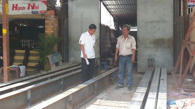 Ông Lương (phải) trong xưởng cơ khí nhỏ của ông