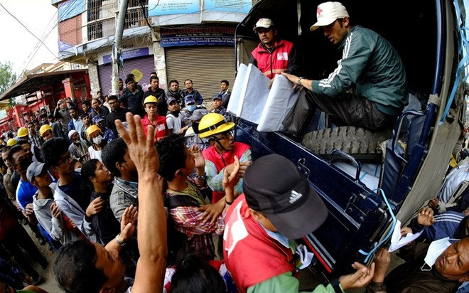Nhân viên Hội Chữ thập Đỏ phát lều cá nhân cho những người dân Nepal