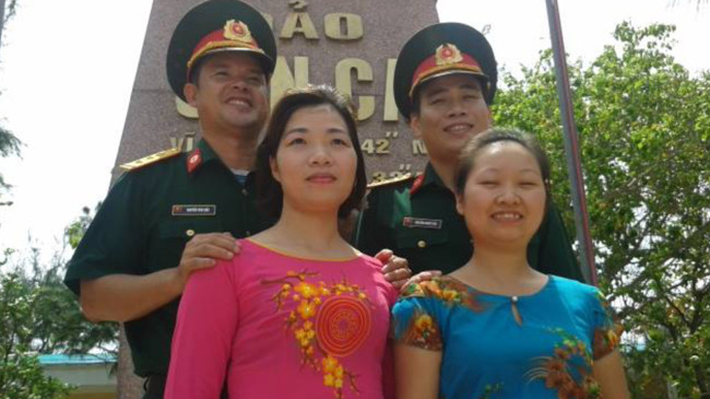 Dưới cột mốc chủ quyền (từ trái qua: Thượng úy Nguyễn Văn Bắc và chị Nguyễn Thị Thanh Thúy (vợ anh Bắc) cùng đại úy Nguyễn Minh Phú và vợ - chị Dương Ngọc Ngà)