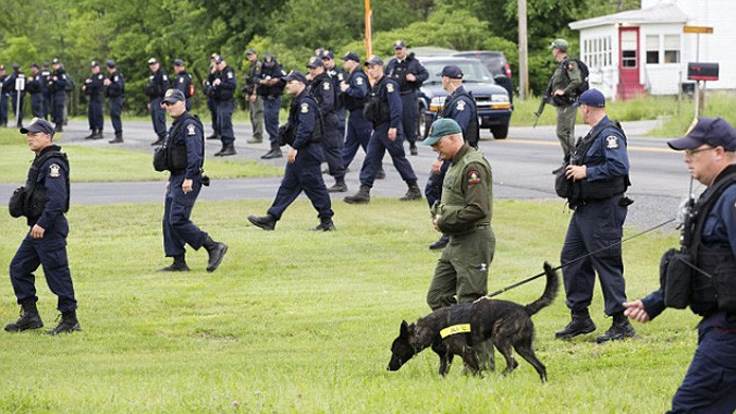 Tìm kiếm dấu vết 2 tù nhân vượt ngục trong tiết trời mưa lạnh. Ảnh: AP