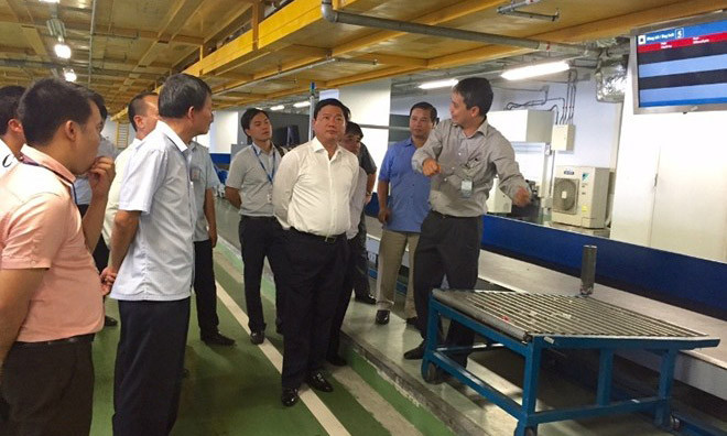 Giám đốc Cảng Hàng không quốc tế Nội Bài Vũ Thế Phiệt báo cáo Bộ trưởng Đinh La Thăng và đoàn công tác quy trình vận chuyển hành lý. Ảnh: Bộ Giao thông vận tải.