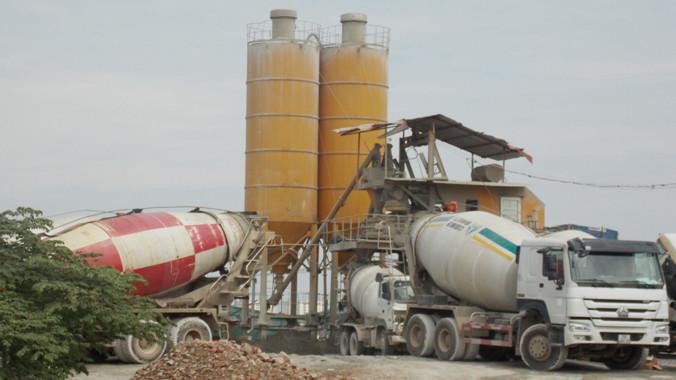 Xe bồn xếp hàng chờ nạp vật liệu từ trạm trộn bê tông trước trụ sở xã Tân Triều sáng 6/7. Ảnh: Anh Trọng