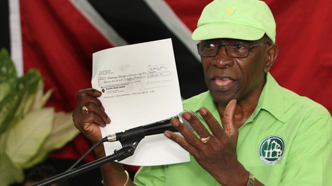 Cựu Phó chủ tịch FIFA Jack Warner trưng ra tấm séc photo trong cuộc nói chuyện trên truyền hình với lời hứa sẽ tiết lộ nhiều tình tiết động trời ở FIFA. Ảnh: AP