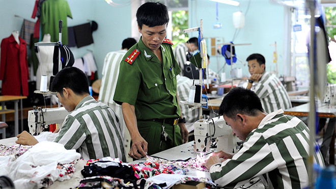 Hướng dẫn phạm nhân trong xưởng may. Ảnh: Xuân Tùng