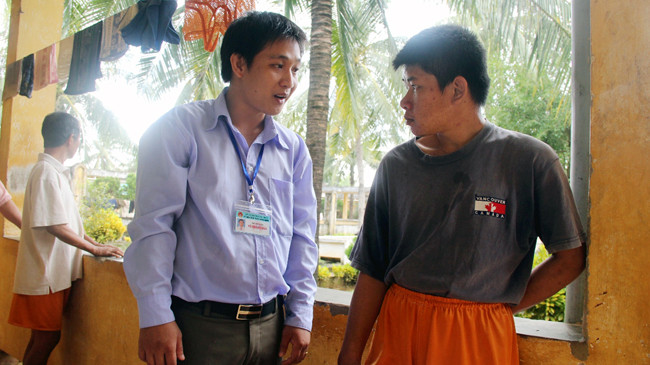 Anh Hảo (trái) trò chuyện với bệnh nhân. Ảnh: H. Văn