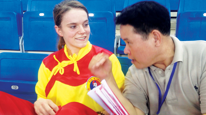 Trưởng môn phái Vạn An, Trương Quang Kim, trao đổi với võ sinh người Pháp Morgan sau bài biểu diễn “Lôi phong phiến” của cô. Ảnh: NP