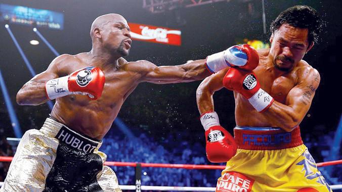 Floyd Mayweather (trái) ra đòn chính xác vào mặt Manny Pacquiao trong trận đấu 300 triệu USD. Ảnh: GETTY IMAGES