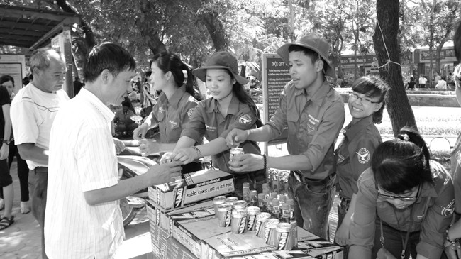 Tình nguyện viên phát tặng nước tăng lực miễn phí cho phụ huynh học sinh