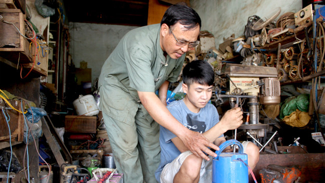 Ông Phạm Ngọc Tỉnh hướng dẫn sửa máy