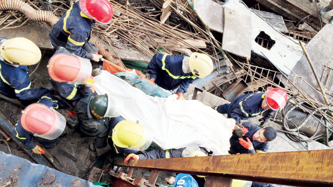 Lực lượng cứu hộ đưa nạn nhân ra khỏi đống đổ nát. Ảnh: P.V