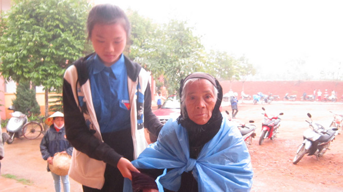 Tình nguyện viên giúp đỡ hộ gia đình chính sách, người nghèo đến nhận quà Tết của Quỹ Thiện Tâm tập đoàn Vingroup. Ảnh: Hoàng Lam