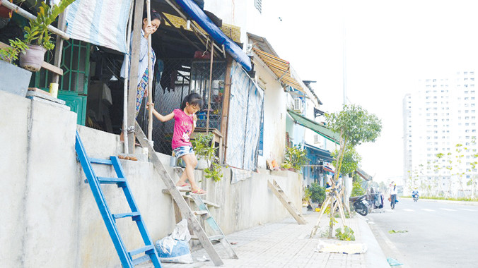 Người dân phải bắc thang để ra vào nhà. Ảnh: Ngô Bình