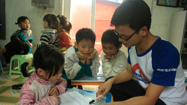 Các tình nguyện viên của dự án Help to Fly đang dạy tiếng Anh cho trẻ em nghèo làng chài Ngọc Sơn (Kiến An, Hải Phòng). Ảnh: Thúy An