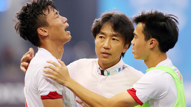 HLV Miura an ủi đội trưởng Quế Ngọc Hải sau trận bán kết thua U23 Myanmar. Ảnh: VSI