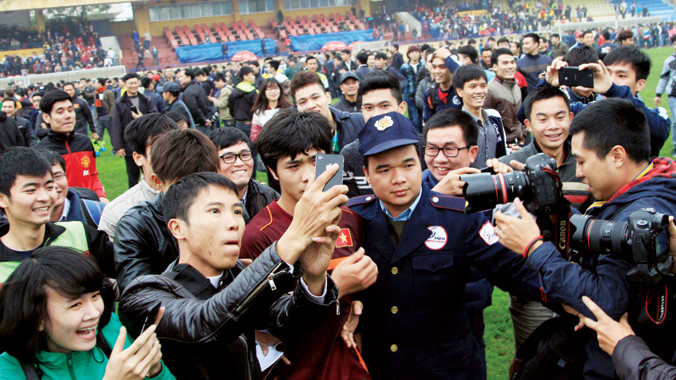 CĐV tràn xuống sân sau trận đấu chụp ảnh tự sướng cùng Công Phượng . Ảnh: VSI