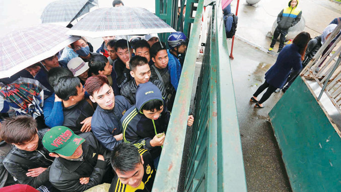 CĐV đội mưa chờ mua vé trận giao hữu ĐT Olympic Việt Nam - U22 Indonesia tại Mỹ Đình ngày 9/3. Ảnh: VSI