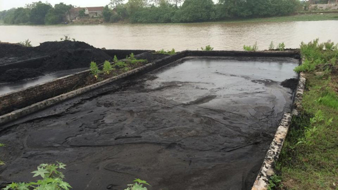 Bể chứa xỉ thải của Cty CP Gạch Kim Chính nằm sát bờ sông. Ảnh: MĐ