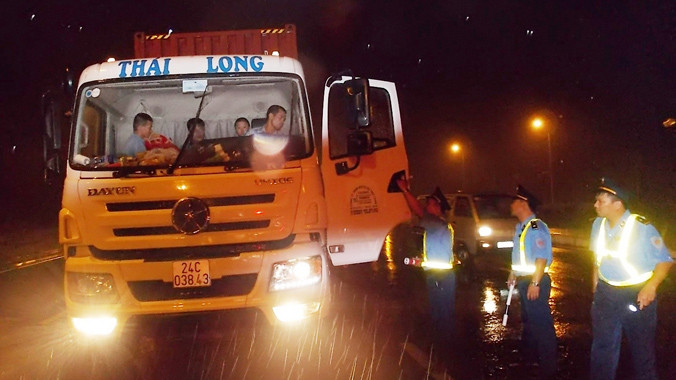 Bị chặn đường và thanh tra vây quanh nhưng tài xế xe tải container vi phạm trên đường 5 rạng sáng 20/7 vẫn chống đối, không xuống xe. Ảnh: Anh Trọng