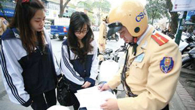 CSGT thành phố Hà Nội đã từng xử phạt HS không đội mũ bảo hiểm ngay tại cổng trường. Ảnh: Minh Đức
