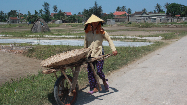 Diêm dân lao lực trên đồng muối dưới nắng nóng khốc liệt. Ảnh: Cảnh Huệ