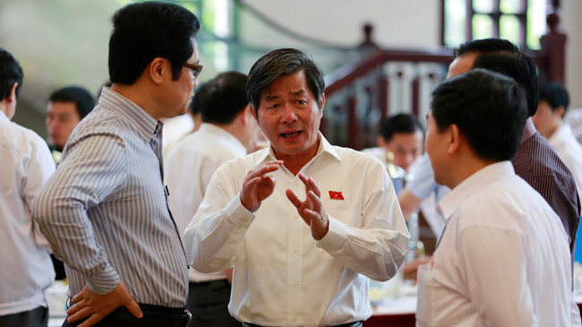 Bộ trưởng Bùi Quang Vinh trao đổi với các đại biểu bên lề Quốc hội. Ảnh: Hồng Vĩnh