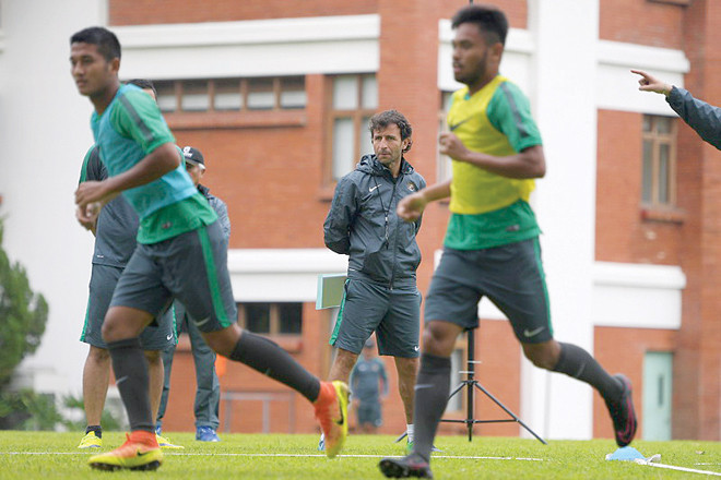 HLV Luis Milla (giữa, đằng xa) theo dõi các cầu thủ Indonesia tập luyện. Ảnh: Okezone.