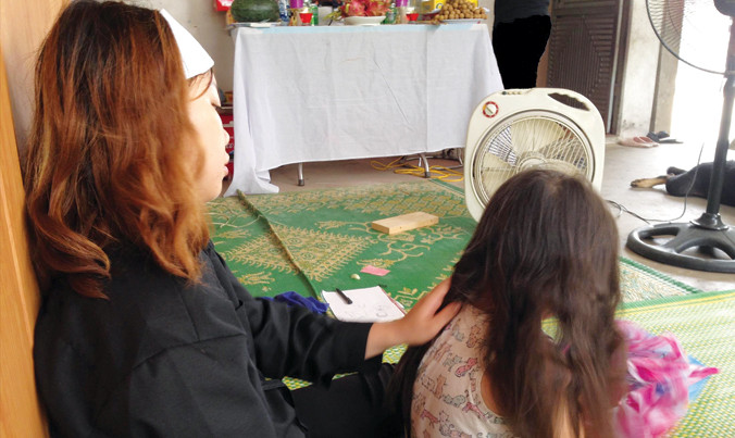 Vợ, con anh Điều trước bàn thờ chồng, cha.