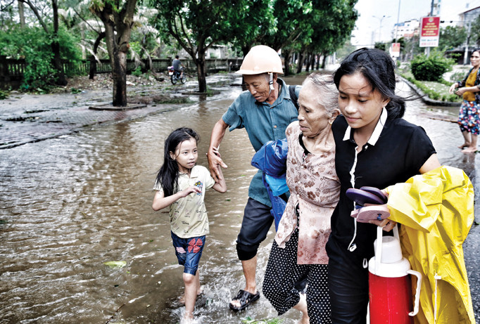 Vợ chồng ông Nguyễn Văn Ngơi cùng con cháu dắt nhau sơ tán khỏi nhà ở Nghi Thủy, thị xã Cửa Lò, Nghệ An lúc 16h30 ngày 15/9. Ảnh: Hồng Vĩnh.