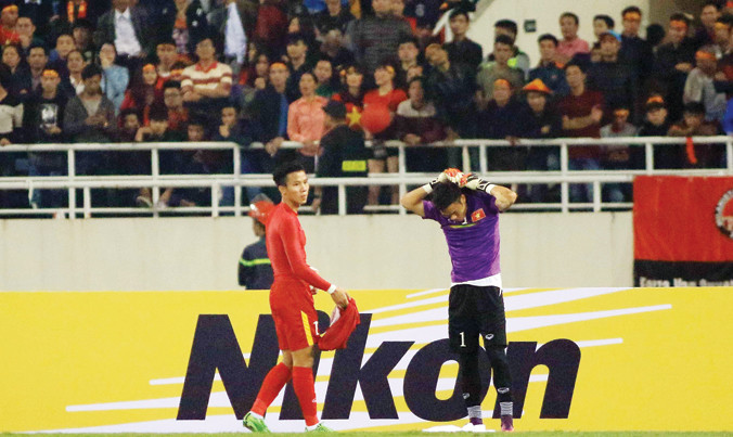 Thủ môn Nguyên Mạnh (phải) cởi áo thủ môn trao lại cho trung vệ Quế Ngọc Hải sau khi bị truất quyền thi đấu vì phạm lỗi cố tình chơi xấu cầu thủ Indonesia trong trận đấu giữa ĐTVN và ĐT Indonesia ngày 7/12/2016. Ảnh: VSI.