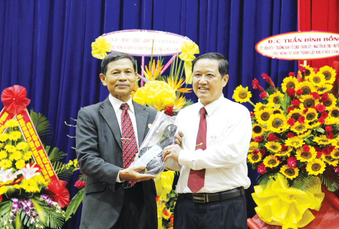 Cựu binh Trần Chiến Chinh trao tặng kỷ vật là dây thắt lưng, bọc đạn, bao súng cho huyện ủy Hòa Vang. Ảnh: Thanh Trần.