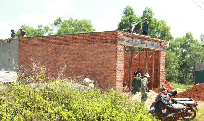 Thợ hồ xây nhà suốt tuần trên những lô đất bị lấn chiếm của ông Hiên.