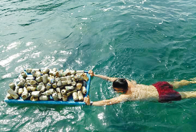 Trung nhặt rác dưới biển. Ảnh: Hồ Trung Tú.