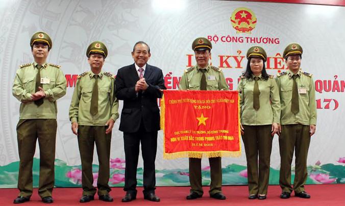 Phó Thủ tướng Chính phủ Trương Hòa Bình trao tặng Cờ Thi đua của Chính phủ cho Cục Quản lý thị trường.