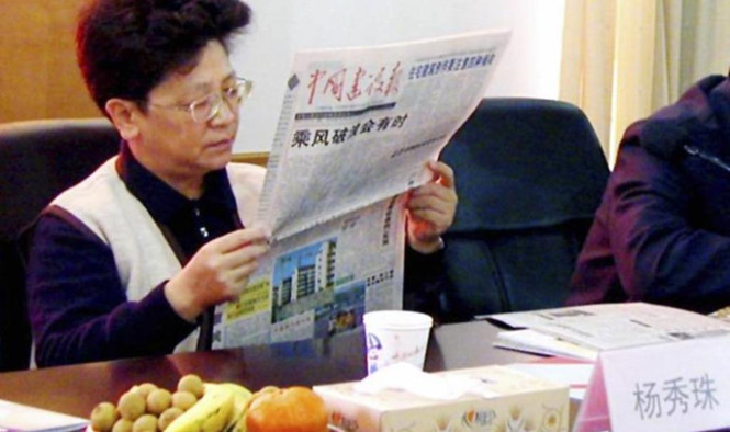 Ảnh chụp bà Dương Tú Châu ngồi đọc báo trong phòng họp tại tỉnh Chiết Giang vào ngày 29.12.2001. Ảnh: Reuters