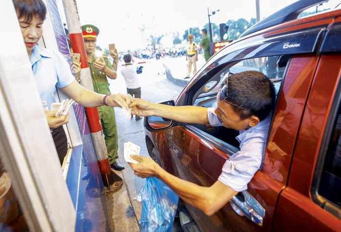 Tài xế trả tiền lẻ qua trạm thu phí BOT số 1 trên quốc lộ 5 (huyện Văn Lâm - Hưng Yên). Ảnh: Như Ý.
